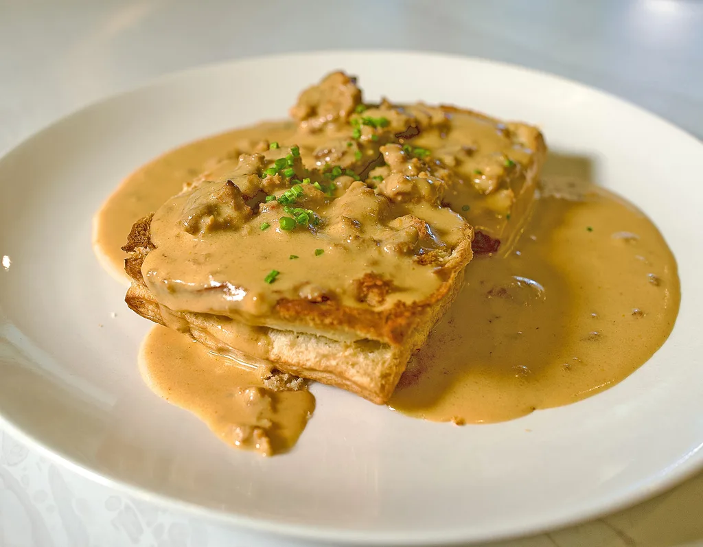 House flaky biscuit under smoked chorizo gravy, garnished with chives