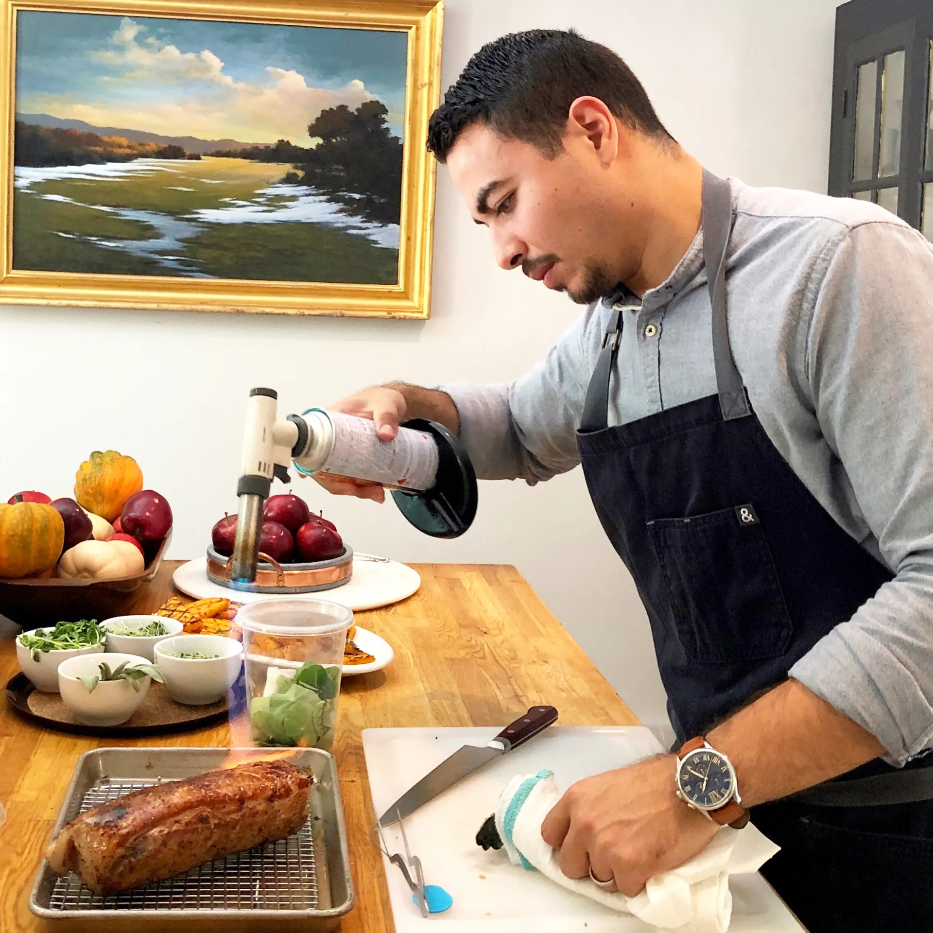 Chef Miguel Calderon finishing a roast with a torch