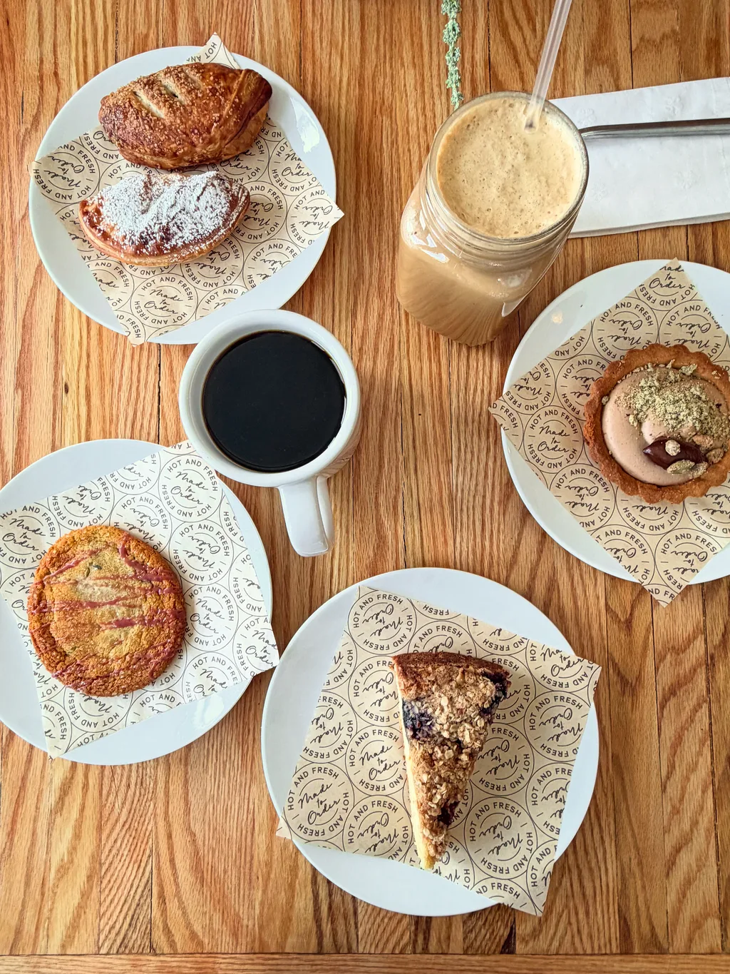 Pastries, coffee, and an iced latte on a table at Alder