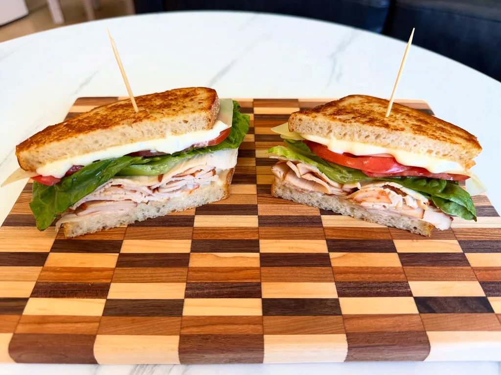 Turkey and Swiss sandwich on toasted sourdough with lettuce and tomato, cut in half