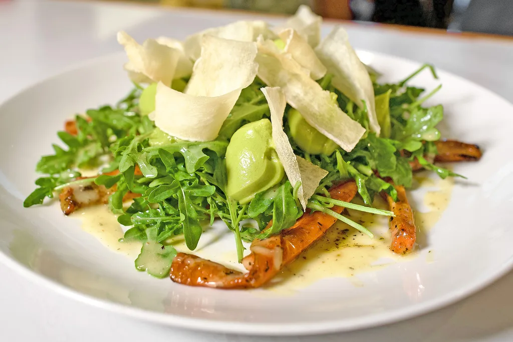 Warm roasted carrot and avocado salad on arugula with crispy yuca and citrus vinaigrette